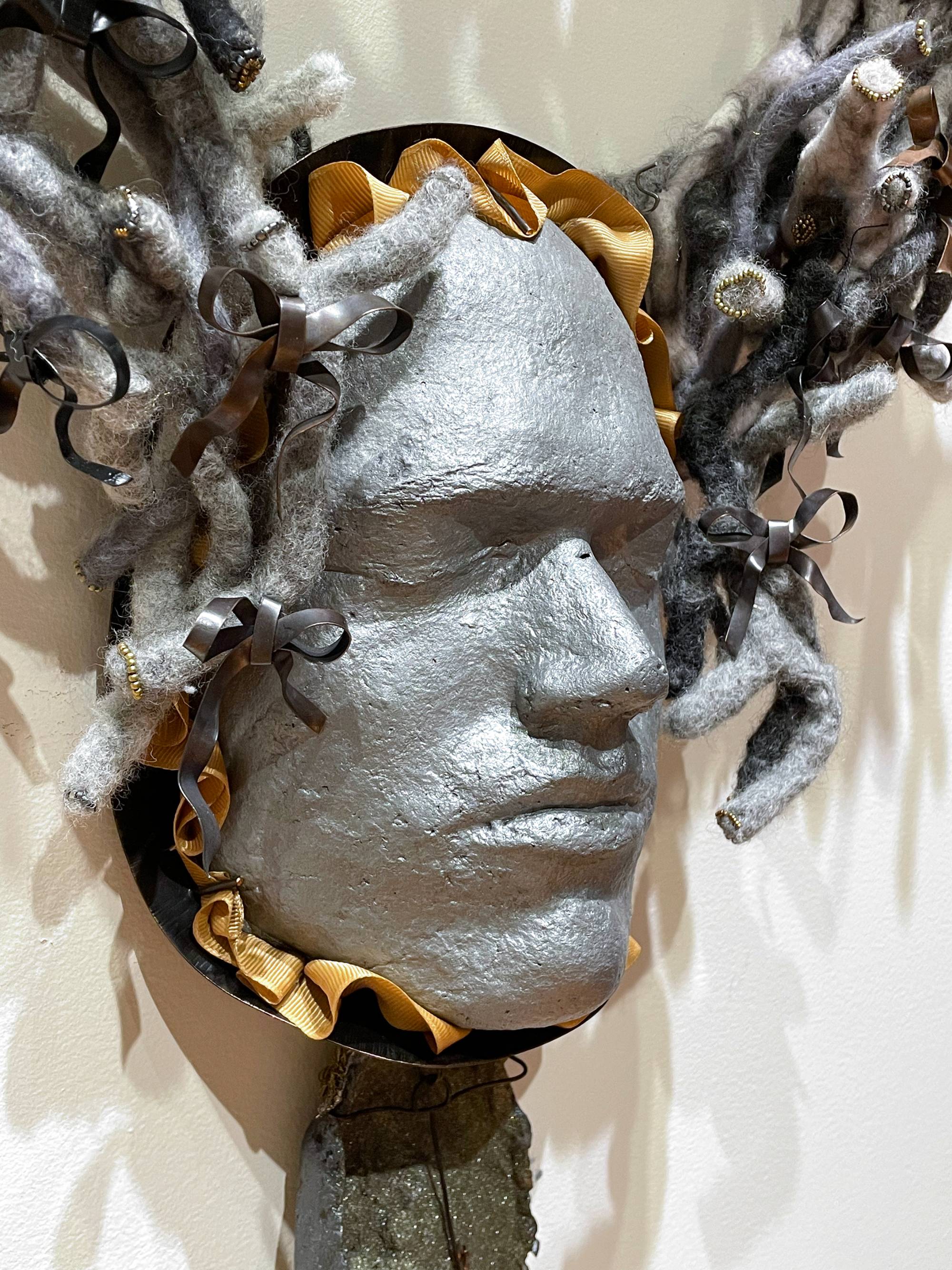 sculpture of a man's face surrounded by wool tubing